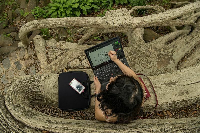 Cyrene Quiamco, 27, sits on a park bench at the Old Mill Park sketching the mill on her Lenovo ThinkPad Convertible Laptop for a snapchat story on May 17, 2016 in Little Rock, Arkansas. Cyrene likes to storyboard and practice sketching out on her laptop first before doing it on snapchat. She says, "It's quicker on my laptop to get it right, then I eventually go into snapchat and execute it."